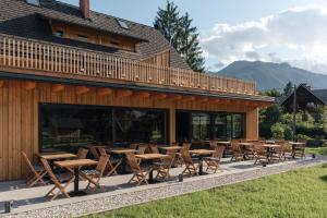 a group of tables and chairs in front of a building at Hotel Majerca in Bohinj