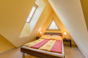 ein Schlafzimmer mit einem Bett im Dachgeschoss mit einem Fenster in der Unterkunft Villa La Mer in Dziwnówek