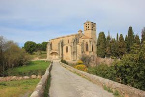 una vieja iglesia con una torre de reloj en un camino de tierra en chez Pauline, en Fontès