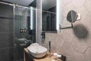 a bathroom with a sink and a shower and a mirror at Hotel Majerca in Bohinj