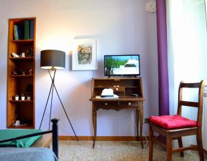 a room with a desk with a television and a chair at DOMUS EVA, dove è nata Tivoli in Tivoli