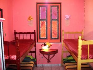 Una habitación con dos camas y una mesa y una ventana. en Arte Brasileira, en Salvador