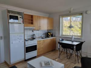 a kitchen with a white refrigerator and a table at Vandrehuset 2 og 3 in Nuuk