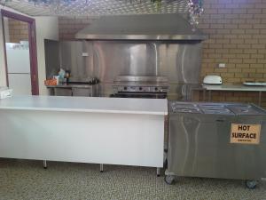 a large kitchen with a stove and a counter top at Jane Eliza Motor Inn in Swan Hill