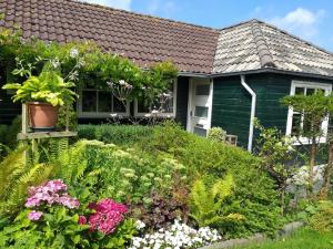 a garden in front of a house with flowers at Holiday Home Canal View in Alkmaar