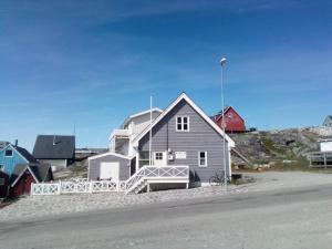 a house on the beach next to a street at Hotel Nuuk - Apartment Nanoq in Nuuk