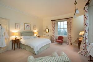 a bedroom with a bed and a chair and a window at Crookston House B&B 