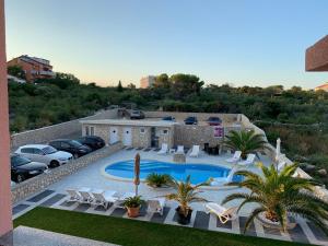 an aerial view of a swimming pool with parked cars at Apartments Albatross in Novalja