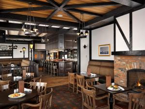a restaurant with tables and chairs and a fireplace at Oak Bay Beach Hotel in Victoria