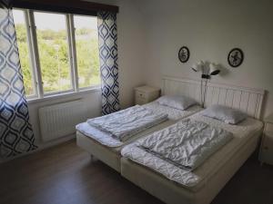 a bedroom with a bed and a large window at STF Hagaby/Lantgården Hostel in Löttorp