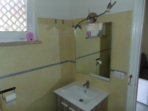a bathroom with a sink and a mirror at Appartamento il Geranio in Quercianella