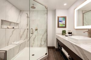a bathroom with a shower and a sink at Buena Vista Suites Orlando in Orlando