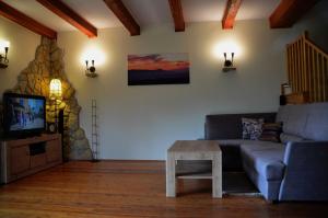 a living room with a couch and a table and a tv at Dom w Beskidach in Stryszawa