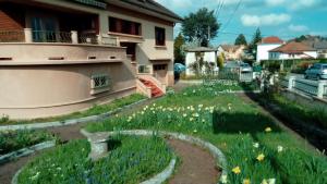 a garden in front of a house with flowers at do mi si la do ré in Exincourt