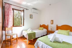 1 dormitorio con 2 camas y ventana en Villa BiniNina, en Binibeca