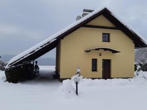 a house with snow on the ground in front of it at Chata Sobolice - Všemina in Všemina