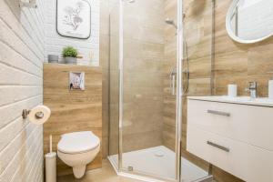 a bathroom with a shower and a toilet and a sink at W&K Apartments - Moon Suite in Koszalin