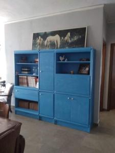 ein blauer Schrank mit einem Pferdegemälde an der Wand in der Unterkunft Konstantin Apartment in Kavala
