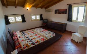 een slaapkamer met een bed en een stoel in een kamer bij Cottage in the green in Misterbianco