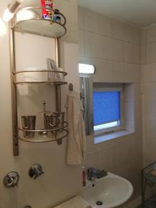 een badkamer met een wastafel, een toilet en een spiegel bij Oase im Park in Berlijn