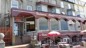 un ristorante con ombrellone di fronte a un edificio di Balmoral Hotel a Blackpool