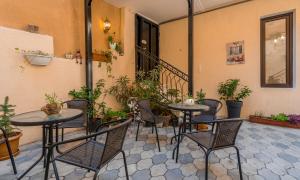a patio with two tables and chairs and plants at Golden Light Hotel in Tbilisi City