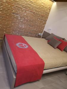 een groot bed in een kamer met een bakstenen muur bij L'Ospitale dei Brilli in Stia