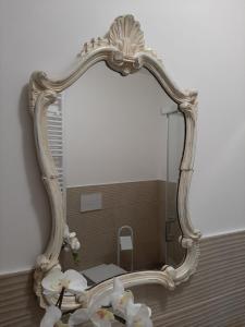 a mirror on a wall with flowers in front of it at B&B Ad un passo dal Cielo in Pietrasecca