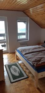 1 dormitorio con 1 cama en una habitación con 2 ventanas en Chata Sobolice - Všemina, en Všemina