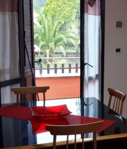 una mesa con 2 sillas, una mesa roja y una ventana en La Casa Del Mosileo, en Vietri di Potenza