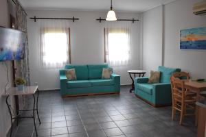 a living room with two blue couches and a table at Melidron Hotel in Skala Kefalonias