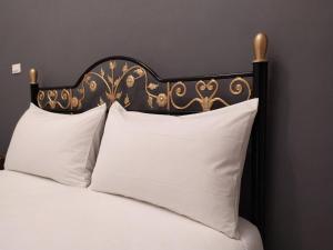 a bed with a black and gold headboard and white pillows at 玖拾捌民宿-98bnb in Hualien City