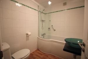 
a white toilet sitting next to a bath tub in a bathroom at Seafield House in Brighton & Hove
