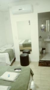 サンパウロにあるHotel Novo Oriente Brásのベッドルーム1室(ベッド1台付)、バスルーム(シンク付)