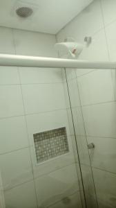 a glass shower in a bathroom with a window at Hotel Novo Oriente Brás in Sao Paulo