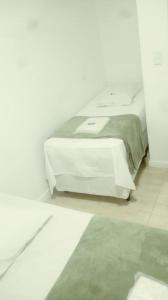 Hotel Novo Oriente Brás في ساو باولو: غرفة نوم بيضاء مع سرير مع طاولة بيضاء