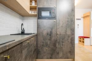 a kitchen with a sink and a microwave at W&K Moon Suite - Studio z balkonem, Garaż, Faktura VAT, in Koszalin