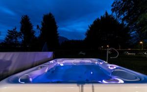 un jacuzzi en el patio trasero por la noche en Hotel Al Sorriso Greenpark & Wellness, en Levico Terme