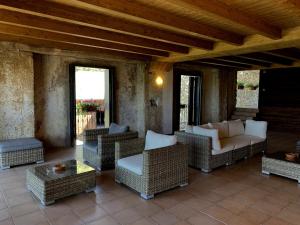 a porch with wicker chairs and a couch and a table at Ca Don Rafel in Castanesa