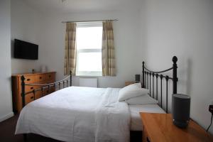 Un dormitorio con una cama grande y una ventana en Seafield House en Brighton & Hove