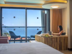 a woman sitting at a desk in a hotel room at Orka Sunlife Resort Hotel and Aquapark in Oludeniz