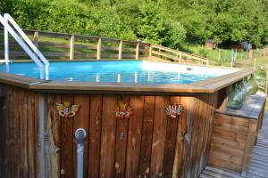 a swimming pool with a wooden fence and a wooden deck at Le Paradis des Animaux in Coublevie