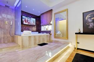 un bagno con vasca, lavandino e specchio di Spanish Diamond Luxury Suites & Jacuzzi a Roma