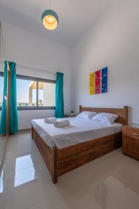 1 dormitorio con 1 cama grande y cortinas azules en Golden Apartments Pool View 1-Bedroom Apartment in G-Cribs, El Gouna, en Hurghada