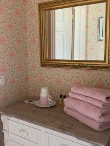 凱里邁基的住宿－Wanhan Apteekin Majatalo，浴室设有镜子和位于柜台上的粉红色毛巾