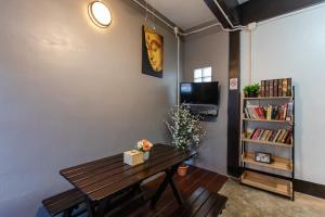 a room with a wooden table and a book shelf at The Z Nite Hostel in Phuket