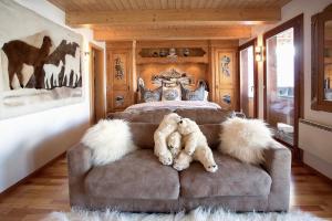 a teddy bear laying on a couch in a bedroom at Stirling Luxury Chalet & Spa in Saas-Fee