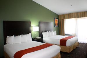 2 camas en una habitación de hotel con paredes verdes en Holiday Inn Express Hotel & Suites Solana Beach-Del Mar, an IHG Hotel en Solana Beach