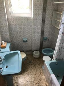 a bathroom with a sink and a toilet and a window at Casa Macareno in Os Muinos