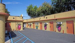 eine Reihe von Gebäuden mit orangefarbenen Türen und lila Vasen in der Unterkunft Griffith Park Motel, in Los Angeles Hollywood Area in Glendale